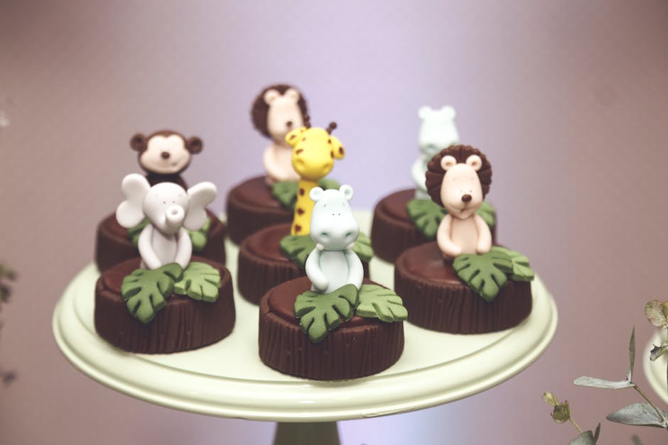 Adorable jungle animal themed chocolate cupcakes with fondant toppers on a display stand.
