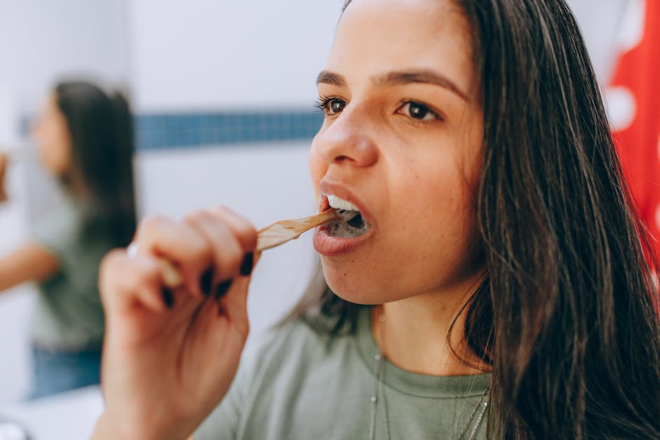 A woman brushing her teeth with a toothbrush