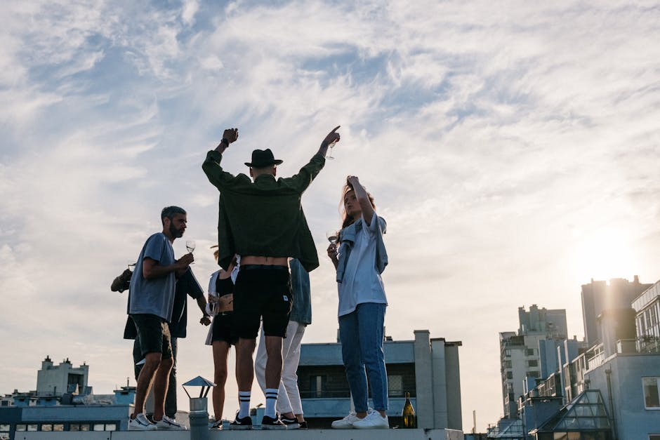 Friends celebrating together on a sunny rooftop with a cityscape view.
