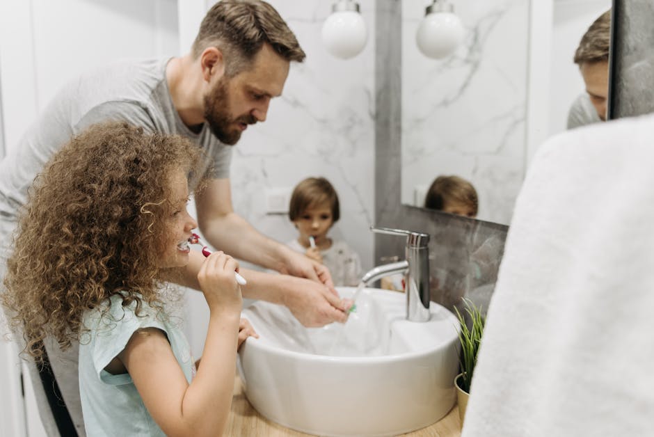 Father and children enjoying morning dental routine by brushing teeth together in elegant bathroom.