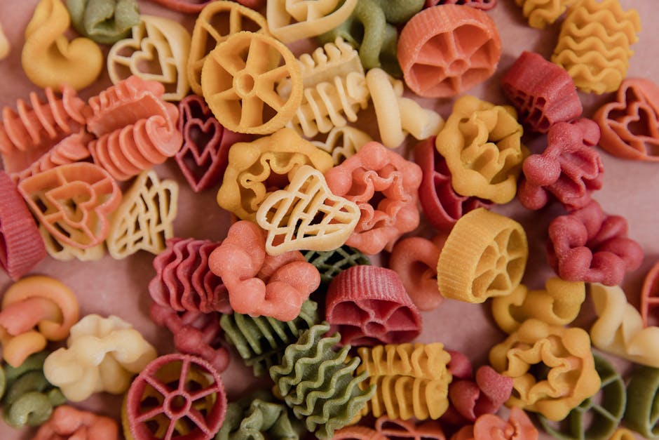 A close-up of vibrant, shaped pasta varieties on a surface.